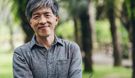 Asian man standing in park