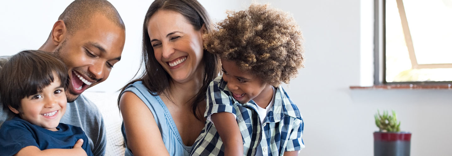 Family of four laughing together