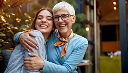 Mother hugging young adult  daughter